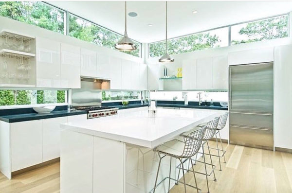 contemporary white kitchen with windows behind cabinets