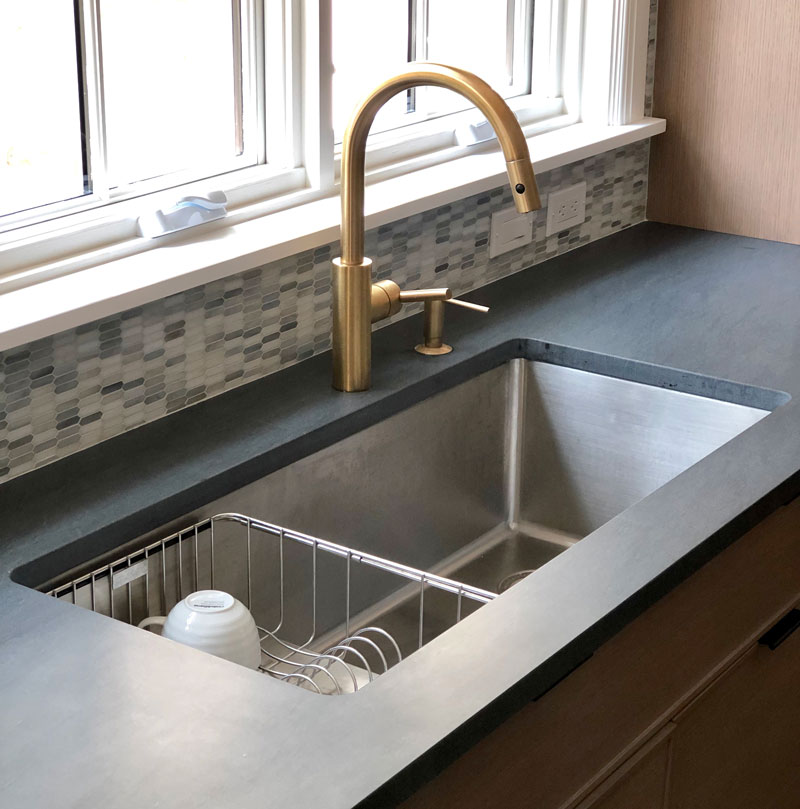 kitchen sink with brass faucet