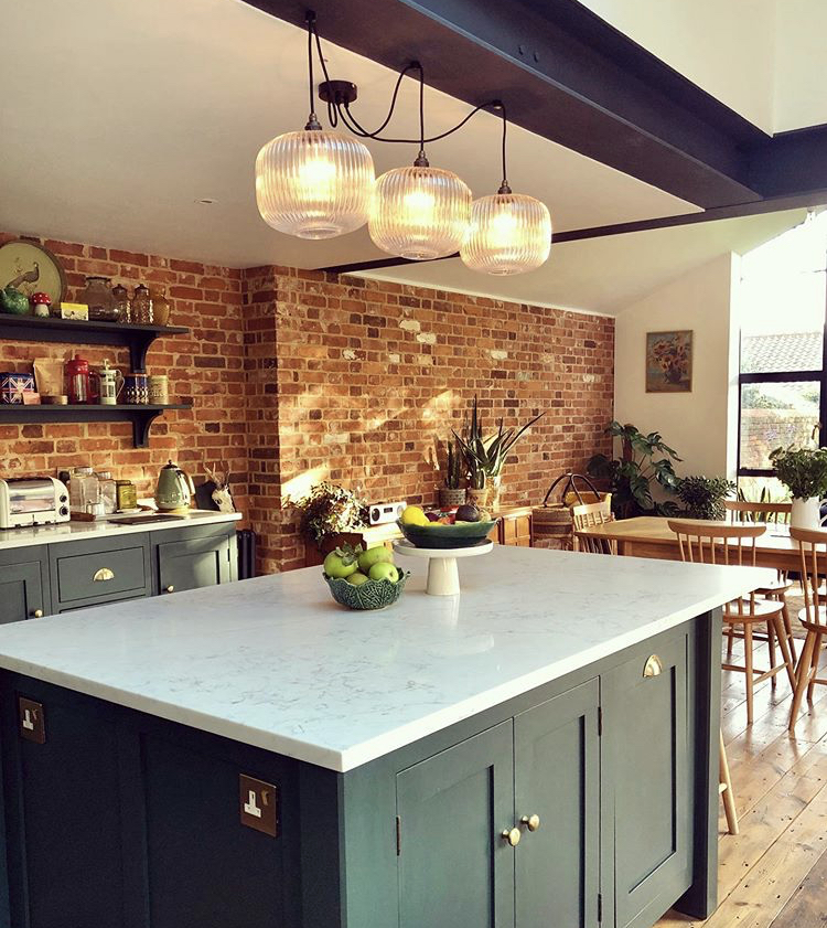 green kitchen with brick wall