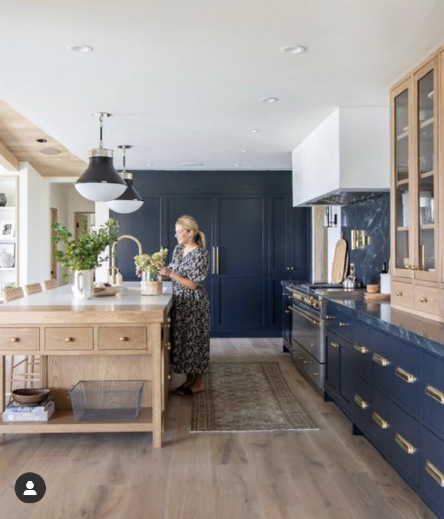woman in navy and light wood kitchen