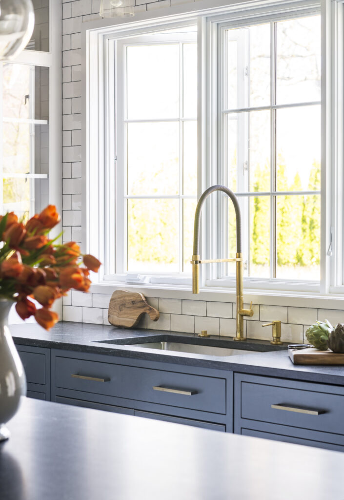 kitchen sink in blue kitchen with brass faucet