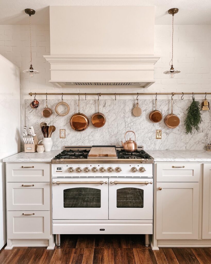 small white kitchen with hanging copper pots