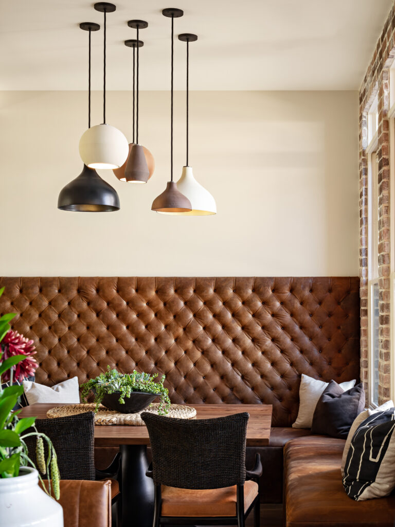 brown leather tufted banquette seating with table and chairs
